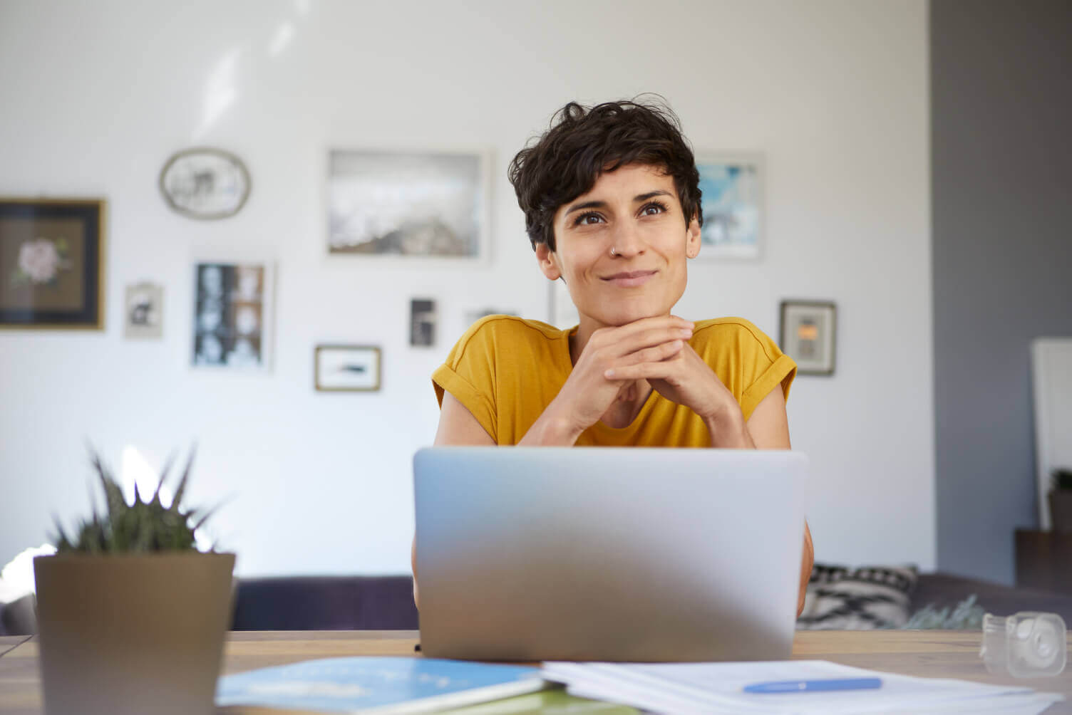 Mujer sonriendo con la vista alta frente a un computador